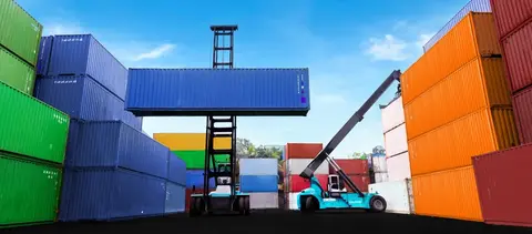 Container stacker cranes lifting up stacking container boxes in yard