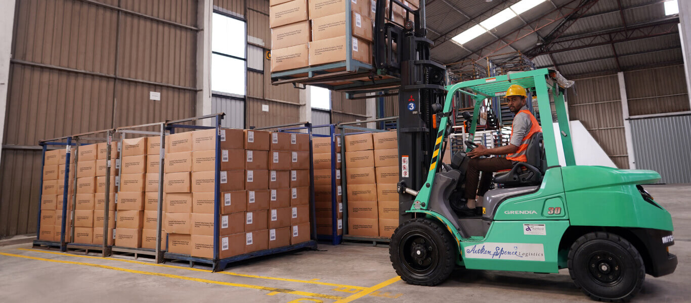 A forklift lifting cargo crates in the warehouse